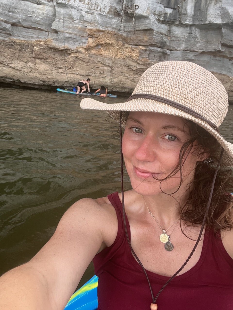 Danette on the water in her straw hat