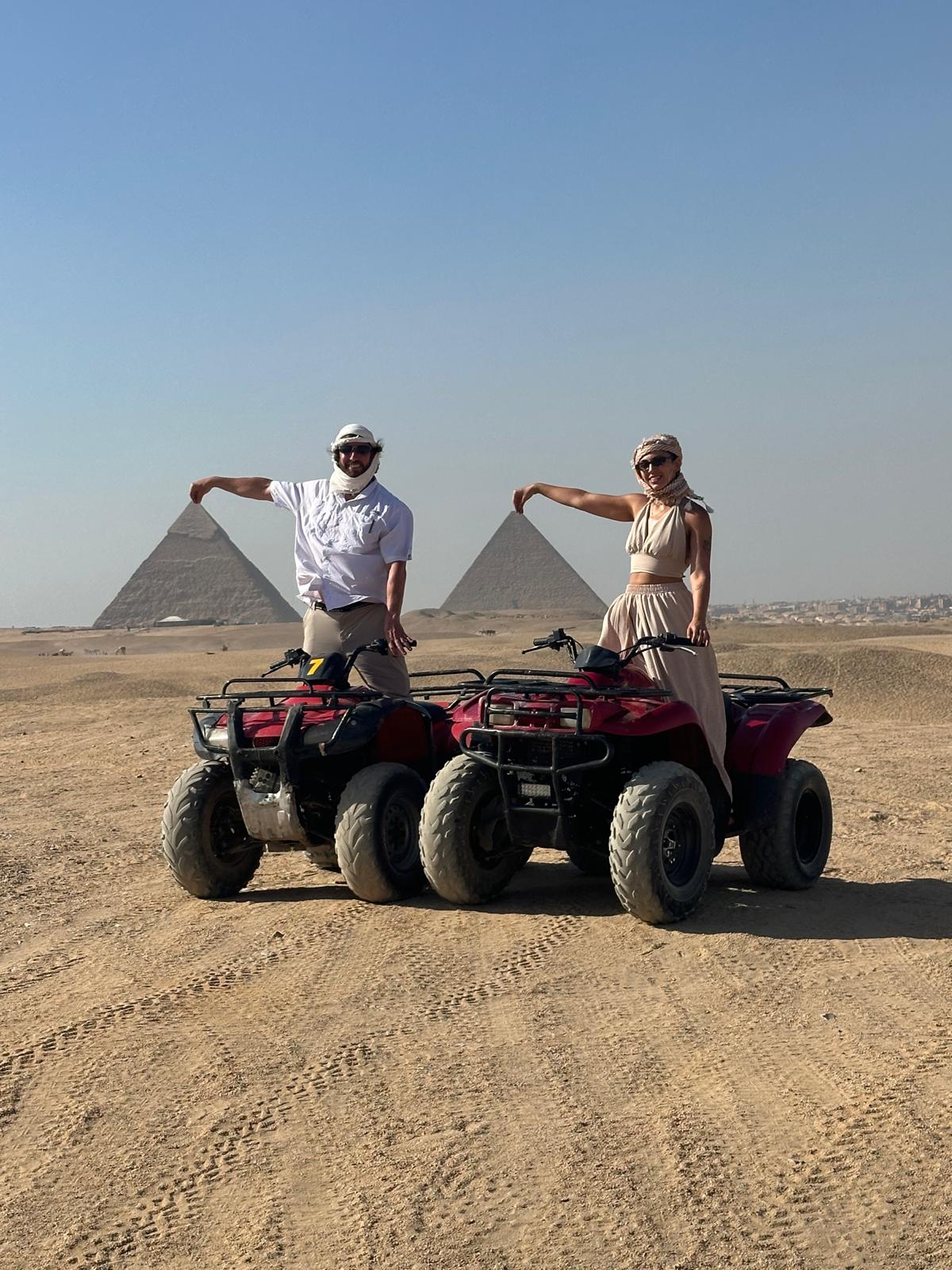 Michael and Gülbahar riding ATVs in front of the Pyramids